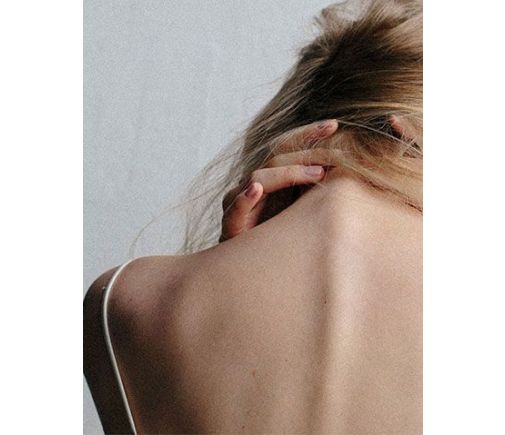 Woman holding the back of her neck in pain