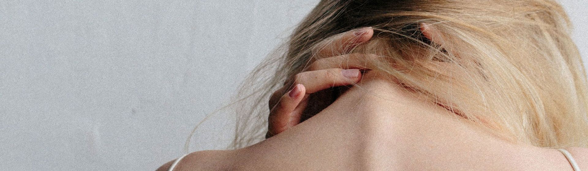 Woman holding the back of her neck in pain