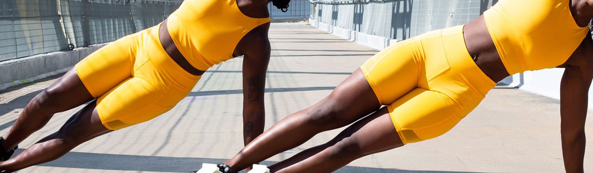 Two women outdoors exercising together.