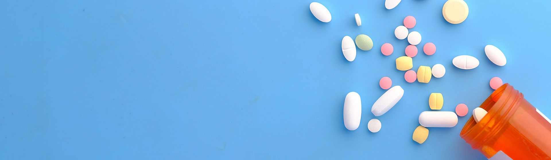 Variety of pills scattered from a bottle.